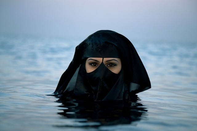 شنای زن سعودی در ساحل با روبنده (عکس)