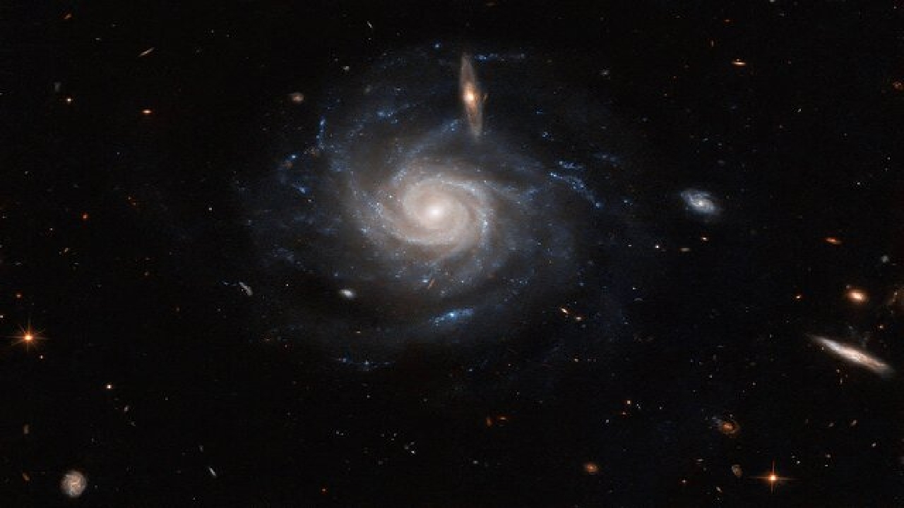 عکس تلسکوپ فضایی هابل از یک کهکشان مارپیچی میله‌ای