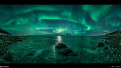 شفق قطبی سبزرنگ از میدان مغناطیسی زمین خارج می‌شود. این شفق قطبی بر فراز آبدره یا فیورد «لینگِنفیوردِن» نروژ واقعا تماشایی است. 