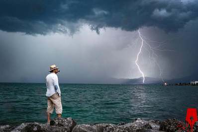 مردی در حالی که صاعقه بر فراز دریاچه ژنو به زمین برخورد می کند در کنار ساحل ایستاده است/
Le Bouveret سوئیس