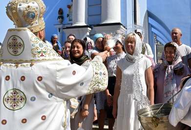 تطهیر عبادت کنندگان در مراسم جشن نان مقدس مسیح در صومعه گنبد طلایی سنت مایکل با آب مقدس/ کیف, اوکراین