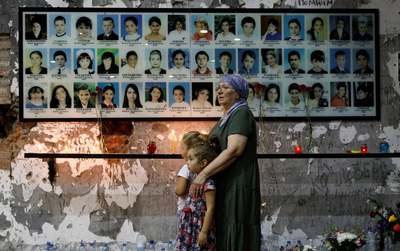 یک زن با دو دختر جوان به مناسبت پانزدهمین سالگرد محاصره مدرسه بسلان در مراسمی که ۳۳۴ تن از مردم جان خود را از دست دادند، شرکت کرده‌اند/ بسلان، روسیه