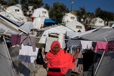 یک زن در میان چادرها در یک اردوگاه موقت برای پناهندگان راه می‌رود/ آتن, یونان