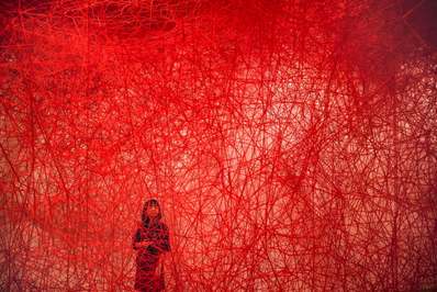 یک زن به سفر نامشخص ، اثر Chiharu Shiota ، در موزه هنر موری نگاه می کند./ توکیو، ژاپن