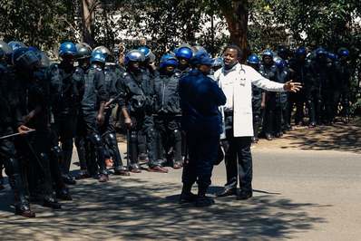 یک پزشک با افسران پلیس ضد شورش که خواستار عبور ایمن از سوی صدها تن از کارکنان پزشکی زیمباوه در برابر ربودن رهبر اتحادیه پزشکان توسط نیروهای امنیتی است, صحبت می‌کند./ هراره, زیمبابوه
